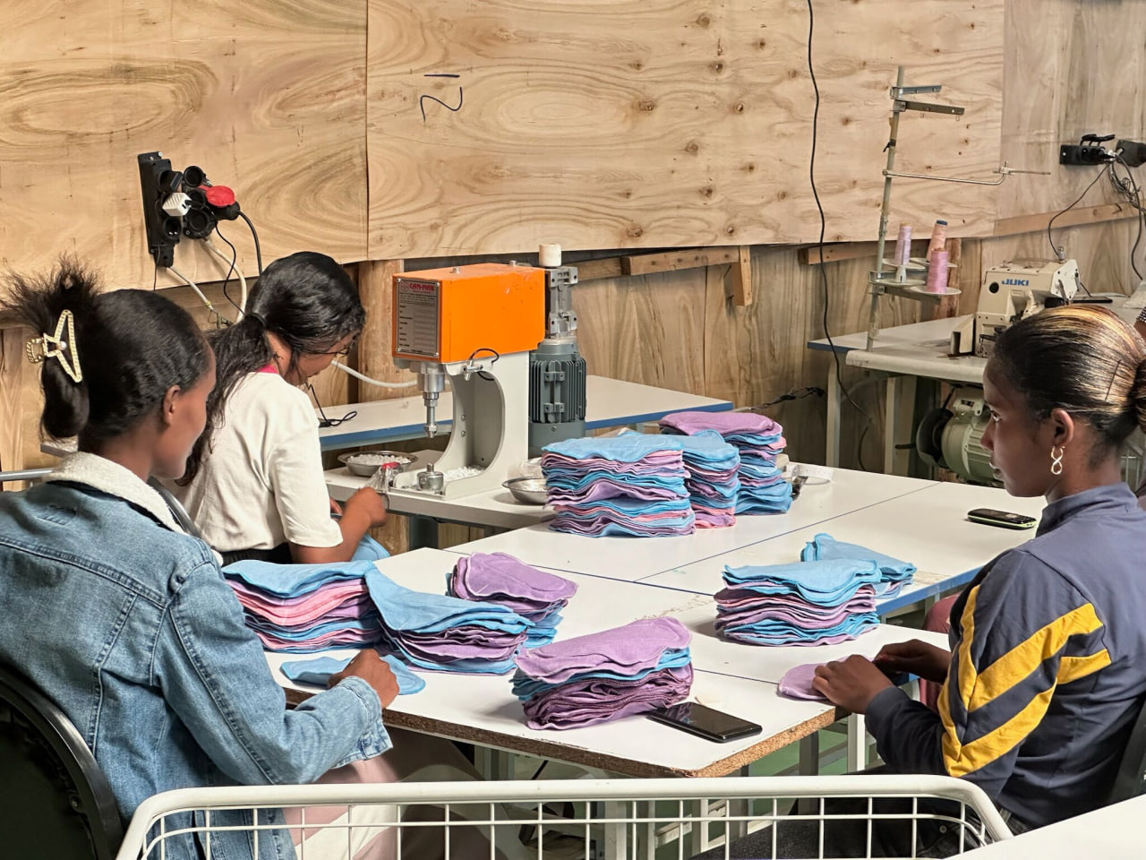 Girls sewing reusable sanitary pads at the Adey Pads workshop